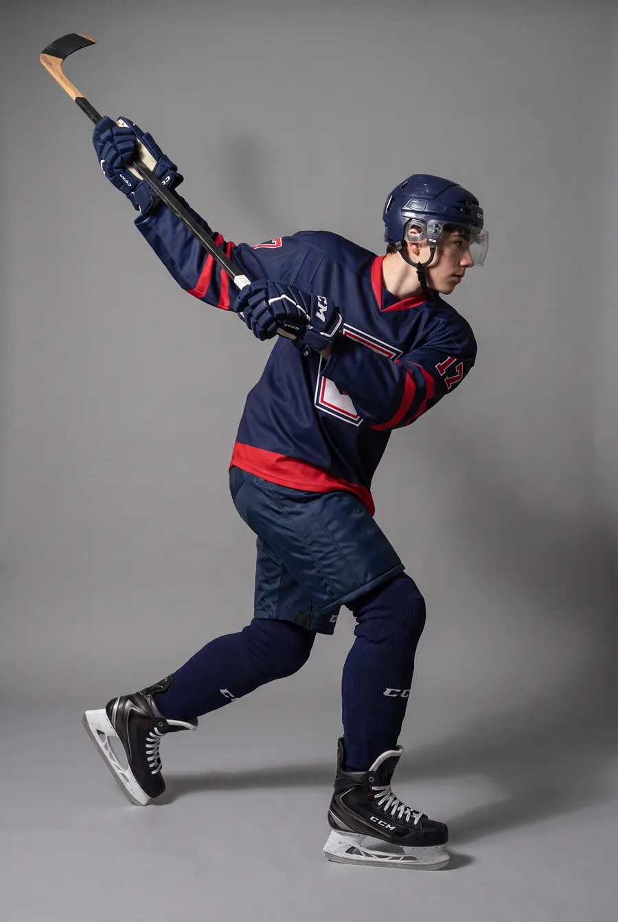 Approved take from the ice-hockey pilot — the same athlete in the kit-plate jersey, red shoulders and sleeves — fictional athlete